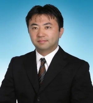 黒いスーツとストライプのネクタイを着用したアジア系の男性の胸から上のポートレート