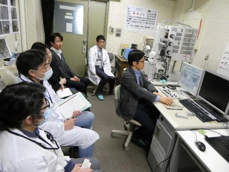 研究室で電子顕微鏡の操作を観察する様子