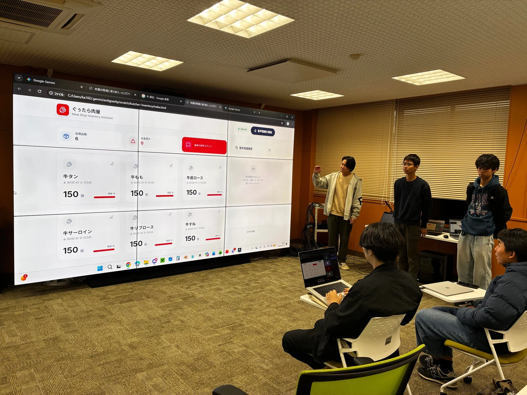 会議室でプレゼンテーションを行う学生たち