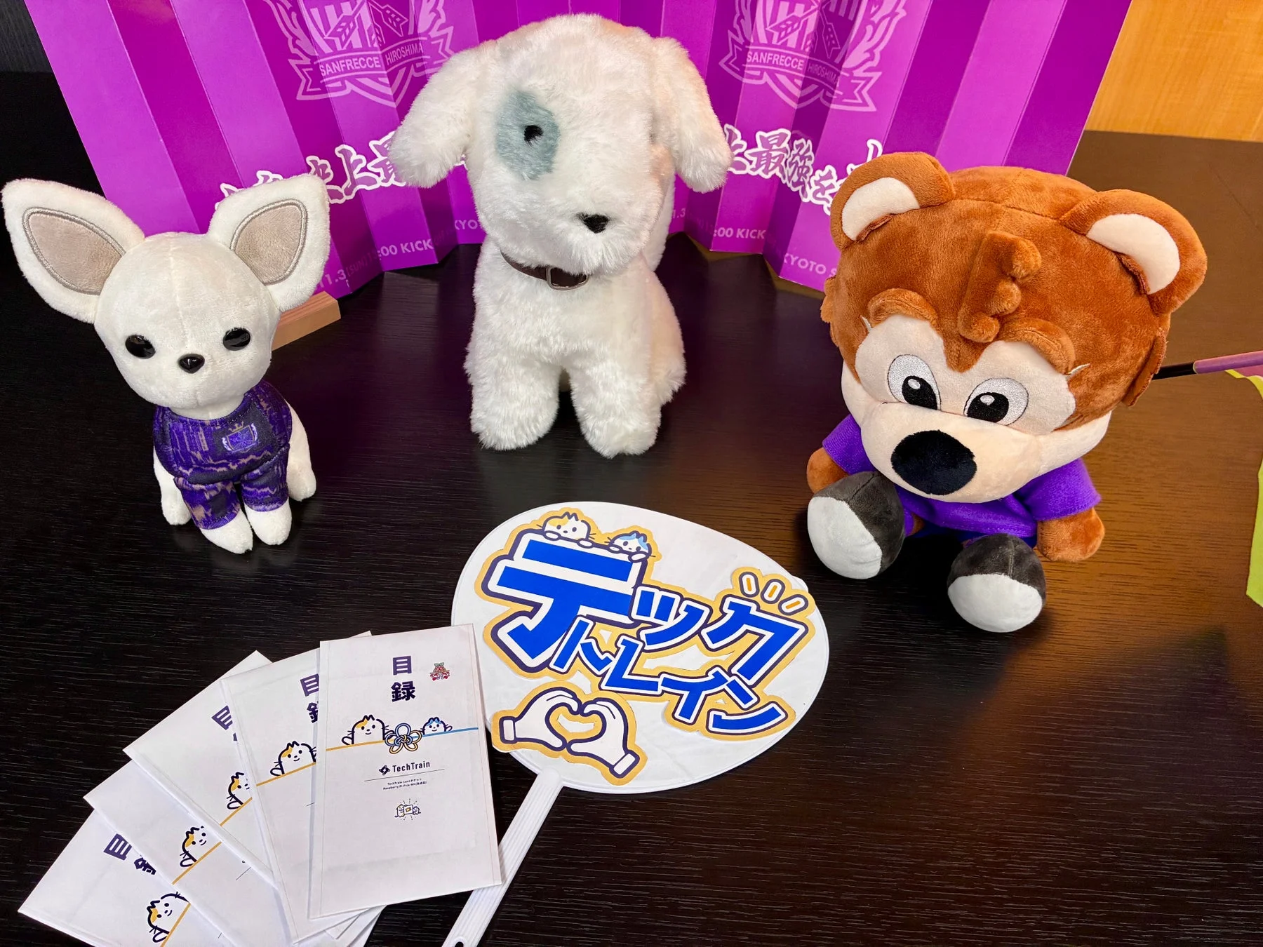 紫色の背景の前で、3体のぬいぐるみが並べられています